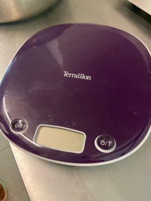 une balance électronique violette posée sur un comptoir