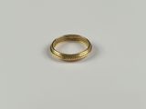 gros plan d'une bague en or sur une surface blanche