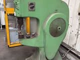 a green machine that is sitting in a warehouse