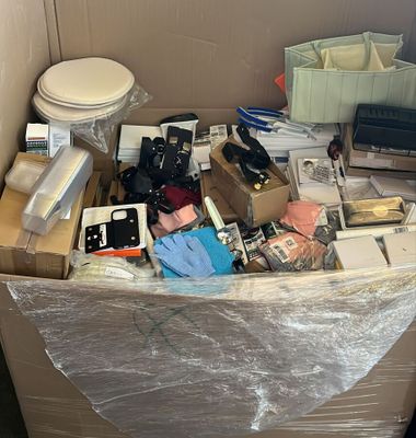 une grande boîte remplie d'objets divers, posée par terre