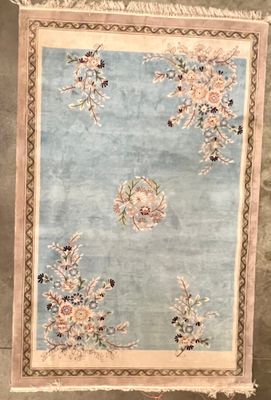 une photo d'un tapis bleu et beige orné de fleurs