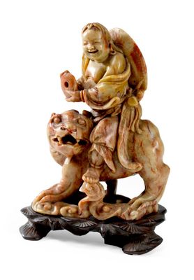 SAGE en stéatite sculptée chevauchant un lion bouddhique sur…