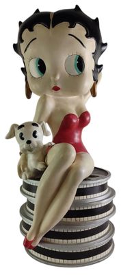 statue d'une pin-up assise sur une pile de pièces de monnaie, accompagnée d'un chien