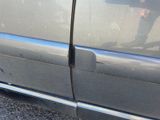 a close up of a car ' s side door with a hole in it