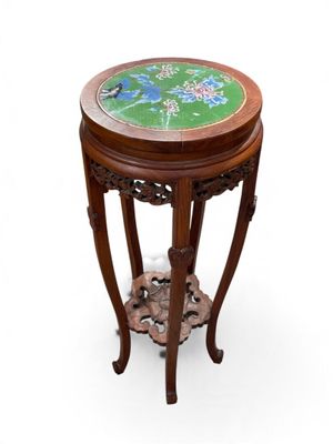 a small wooden table with a green and blue design on it