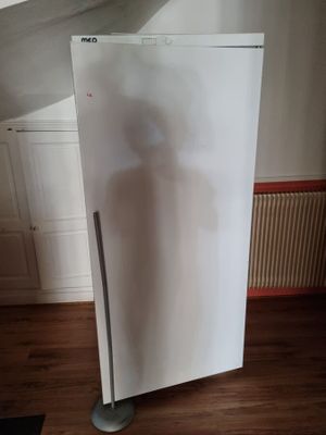 un réfrigérateur blanc au milieu d'un parquet