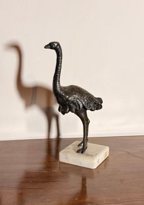 une statue représentant une autruche et un oiseau posée sur une table