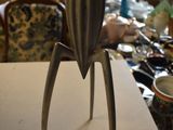 a metal object on a table in the middle of a cluttered room