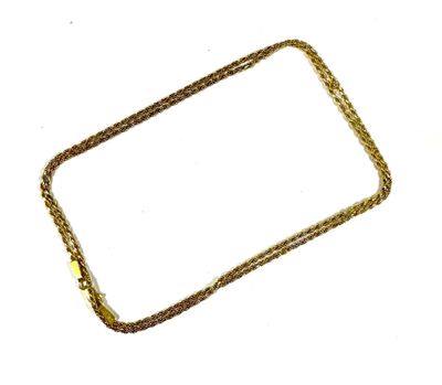 a close up of a cell phone with a chain on a white surface