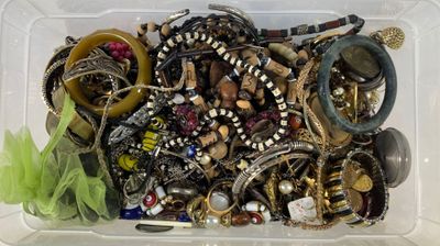 a plastic container filled with assorted jewelry and bracelets