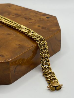 une image représentant une boîte en bois sur laquelle est posée une chaîne en or