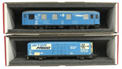 deux wagons bleus posés dans une boîte sur une surface blanche