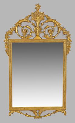 un miroir richement sculpté, avec un cadre doré sur fond gris