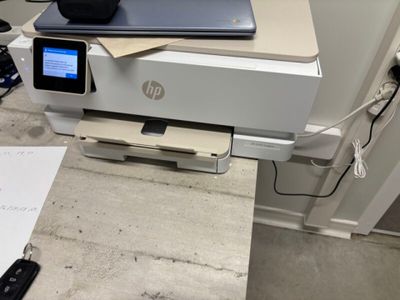 a printer sitting on top of a desk next to a cell phone