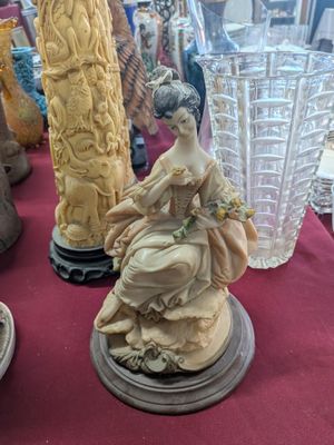 many vases that are on a table with a red table cloth