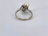 a close up of a ring with a pearl on it