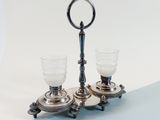 pair of silver plated candlesticks with glass holders on a blue and white background
