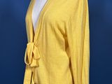 a woman ' s yellow cardigan sweater on a mannequin dummy