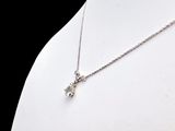 silver necklace with a cross pendant on a mannequin neck