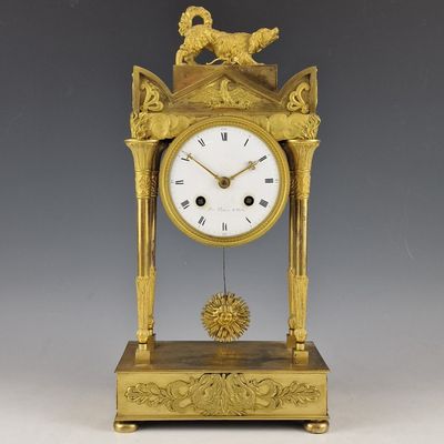 une horloge en or surmontée d'un oiseau