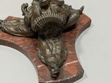 a bronze statue of a man holding a fish on a wooden plaque