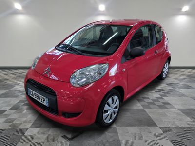 la petite voiture rouge est garée sur un sol en damier