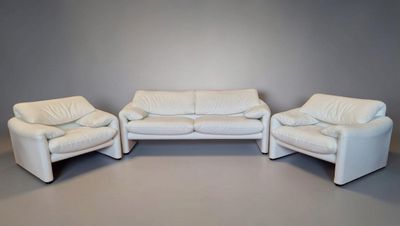three white leather couches and two chairs in a room