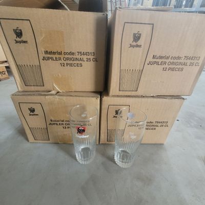 three empty glasses sitting on top of a pile of cardboard boxes