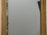 a gold framed mirror on the wall in a bathroom