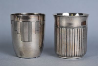 two silver cups sitting next to each other on a table