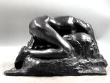 statue of a woman laying down on a rock with her hands on her head