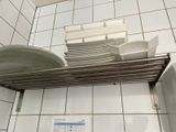 une pile d'assiettes et de bols posée sur une étagère dans une salle de bains