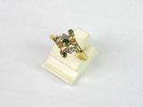 une image représentant une bague en or sertie de pierres vertes et blanches