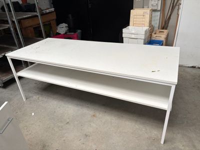 a white table with a shelf on it in a garage