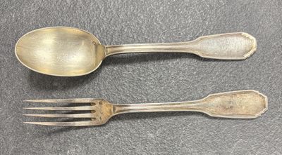 deux cuillères et une fourchette en argent sur une table
