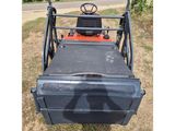 a close up of a tractor with a trailer in the middle of a field