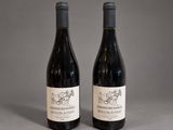 two bottles of wine sitting next to each other on a table