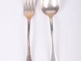 two silver spoons and a fork on a white surface