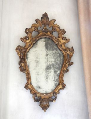 a mirror hanging on the wall next to a curtain
