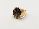 a close up of a gold signet ring on a white surface
