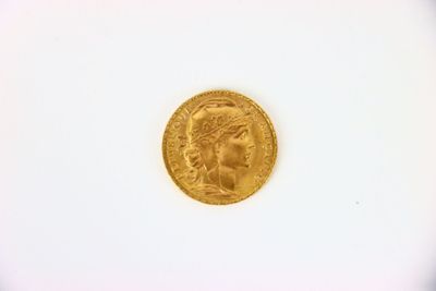 gros plan d'une pièce d'or sur une surface blanche