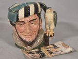 a ceramic figurine of a man with a bird on his arm