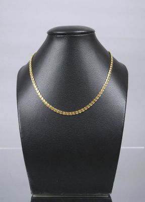 a black mannequin with a gold chain on it