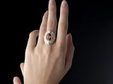 a woman ' s hand with a diamond ring on it