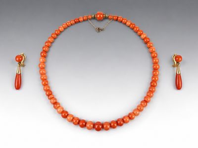 un ensemble composé d'un collier et de boucles d'oreilles en perles orange, avec un fermoir doré