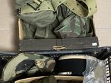 une boîte remplie d'objets militaires posée par terre