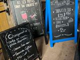 trois tableaux noirs posés les uns à côté des autres sur le sol
