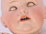 a close up of a baby doll with a surprised look on it ' s face