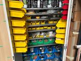 a metal cabinet with many bins of items in it