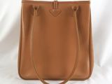 a tan leather handbag on a white background